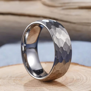 A silver hammered stainless ring placed in the center of a cut small tree stump