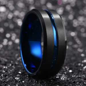 A blue inlayed ring standing in a black sandpaper like background
